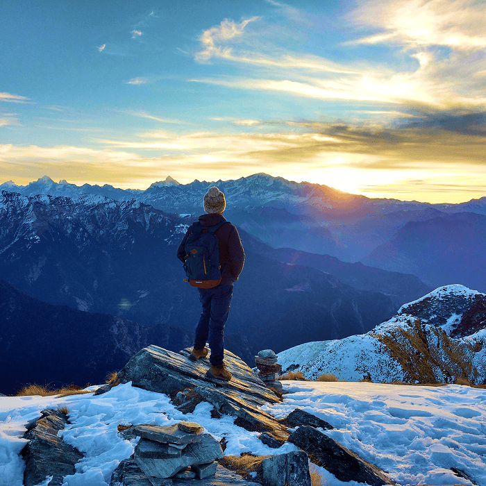 Un trekkeur devant une vue de montagnes enneigées, vivez une expérience hors du commun